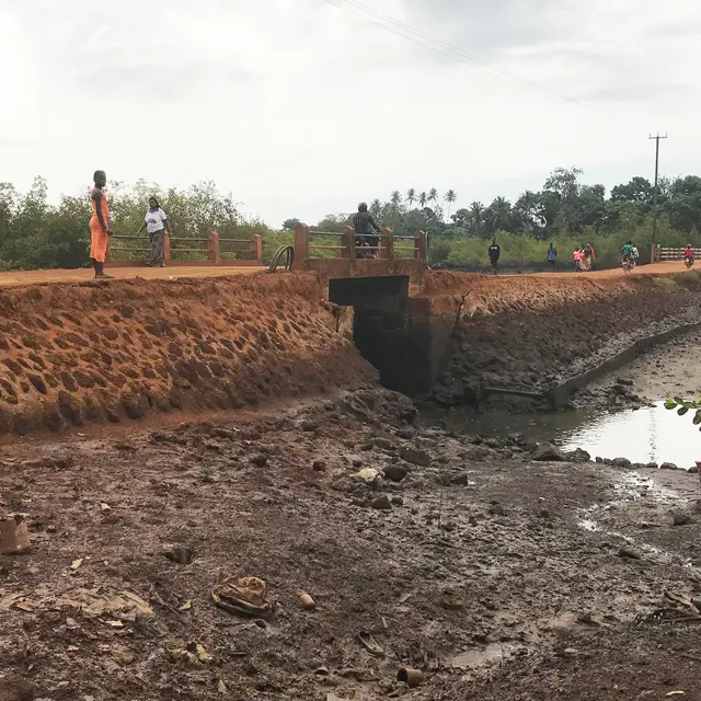 Bruin pad met kleine brug en enkele staande mensen